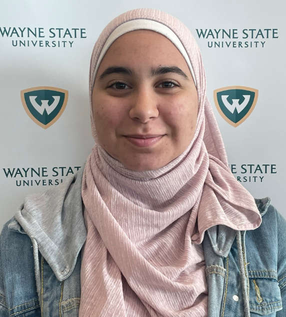 A picture of me during freshman orientation standing in front of a wallpaper containing the Wayne State Logo